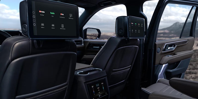 GMC Yukon XL interior featuring second-row captain’s chairs and rear entertainment screens.